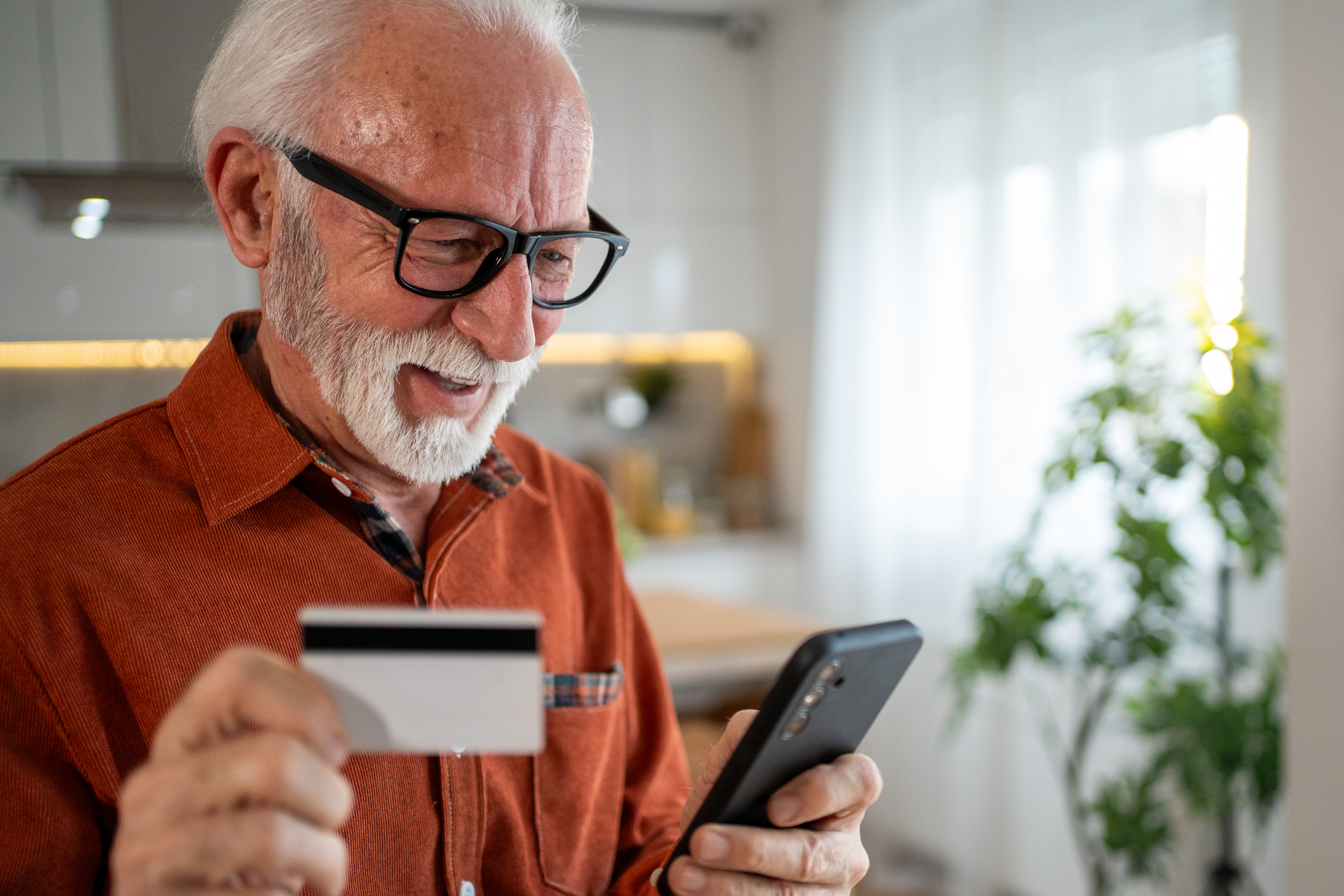 a happy chap using his debit card on his smartphone