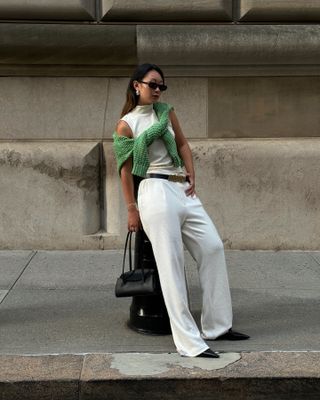 Influencer wears a colourful jumper on top of a neutral outfit.