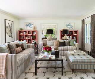 living room with two striped sofas and plaid ottoman patterned rug
