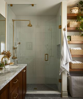 transitional style bathroom with antique wood vanity and marble countertop with a walk in shower