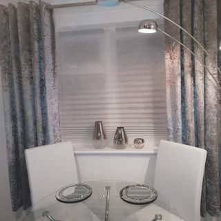 room with white chair floor lamp glass top table
