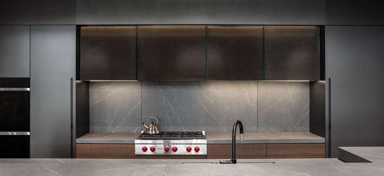 A kitchen with gray cabinets and backsplash