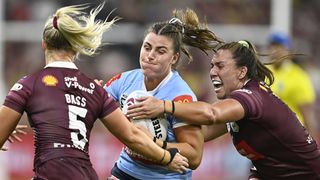  Blues player is tackled by two Maroons in the Women's State of Origin