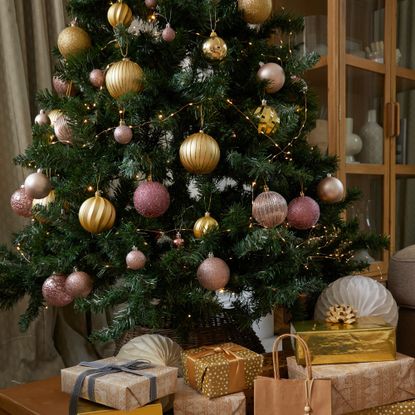 A Christmas tree decorated with metallic baubles in a living room