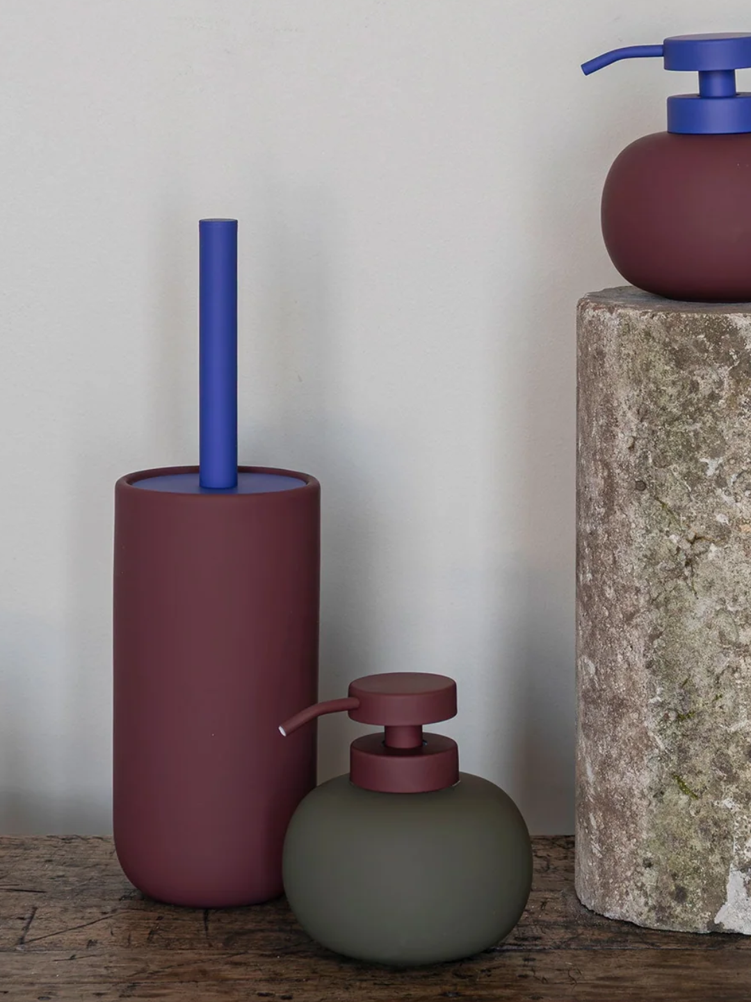 A toilet brush with a burgundy base and a cobalt blue top