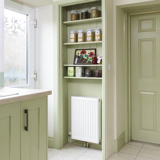 white and green kitchen with boiler installed in pantry