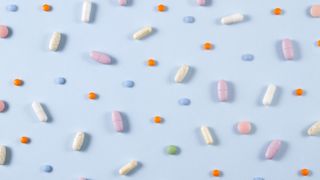 different sized and coloured pills on blue background