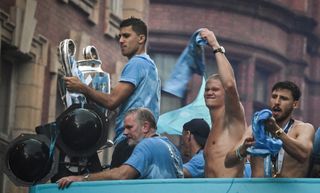 Manchester City players celebrate their treble triumph in a bus tour through the city in June 2023.