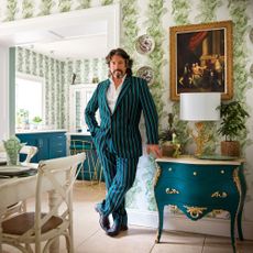 Laurence Llewelyn-Bowen standing beside a dining table in an open plan kitchen diner