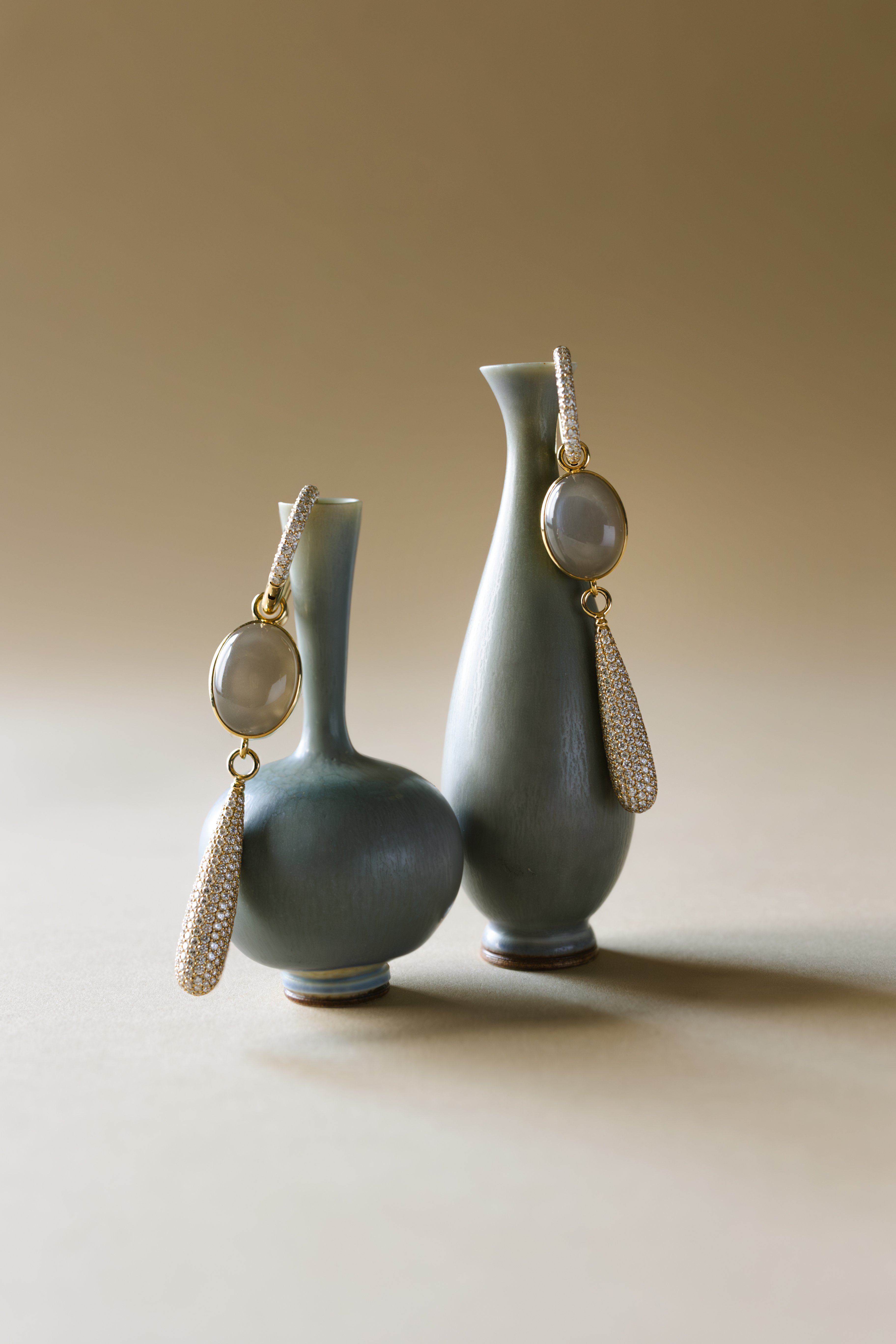 ceramics and jewellery against green and brown backgrounds