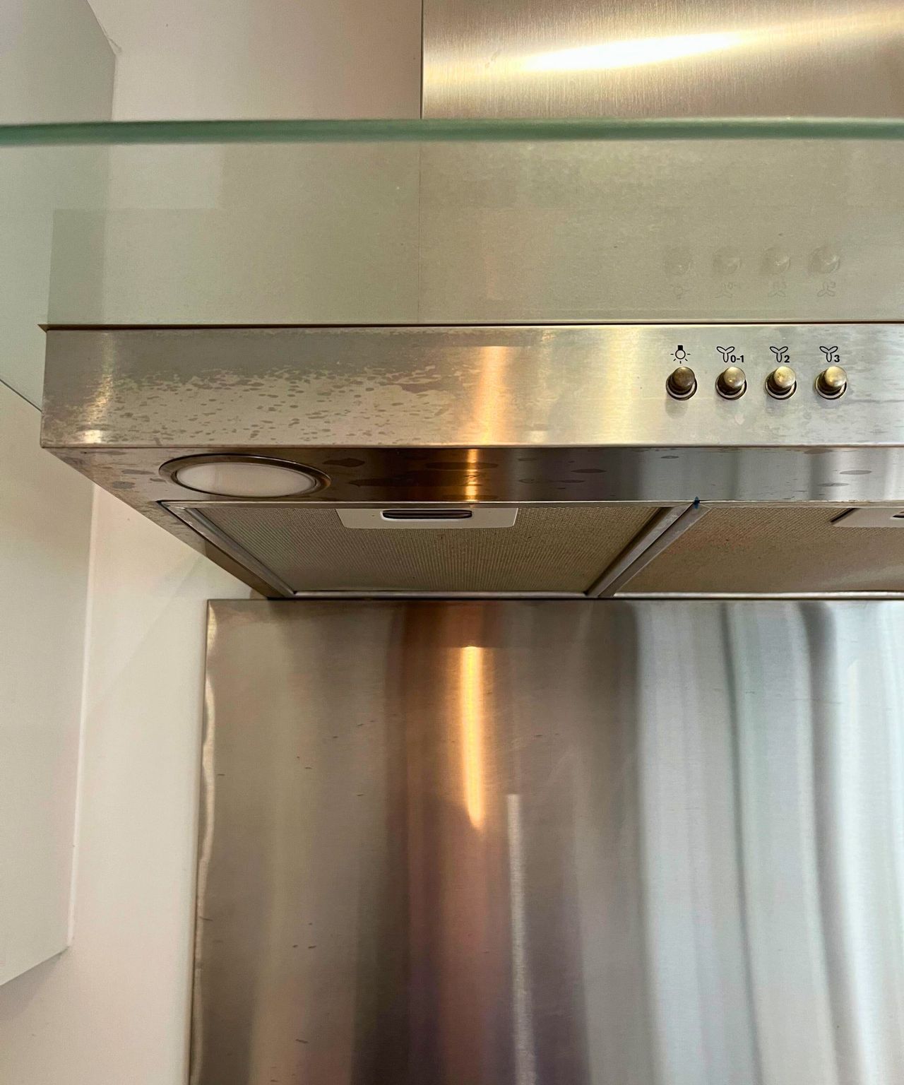 My grimy and streaky stainless steel extractor hood. The glass above it is covered in dust and grease