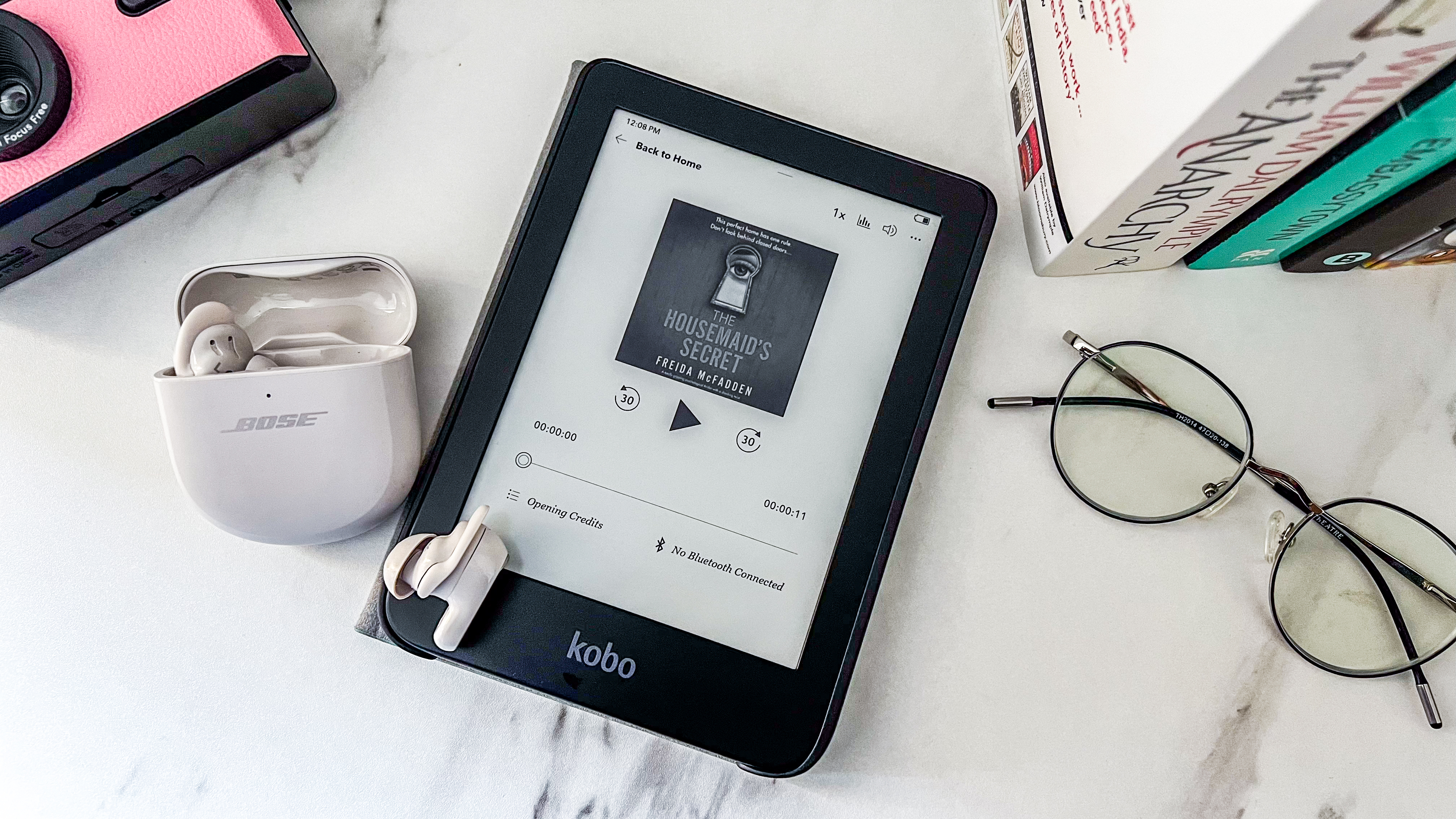 An audiobook on the Kobo Clara BW with a pair of true wireless earphones