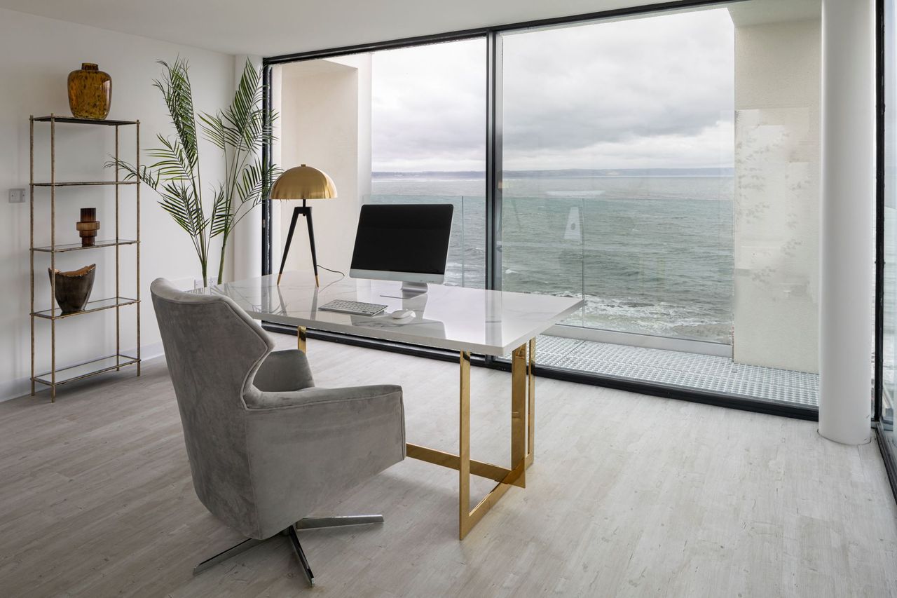 The office of the Lighthouse looks out onto the sea with tall bifold windows