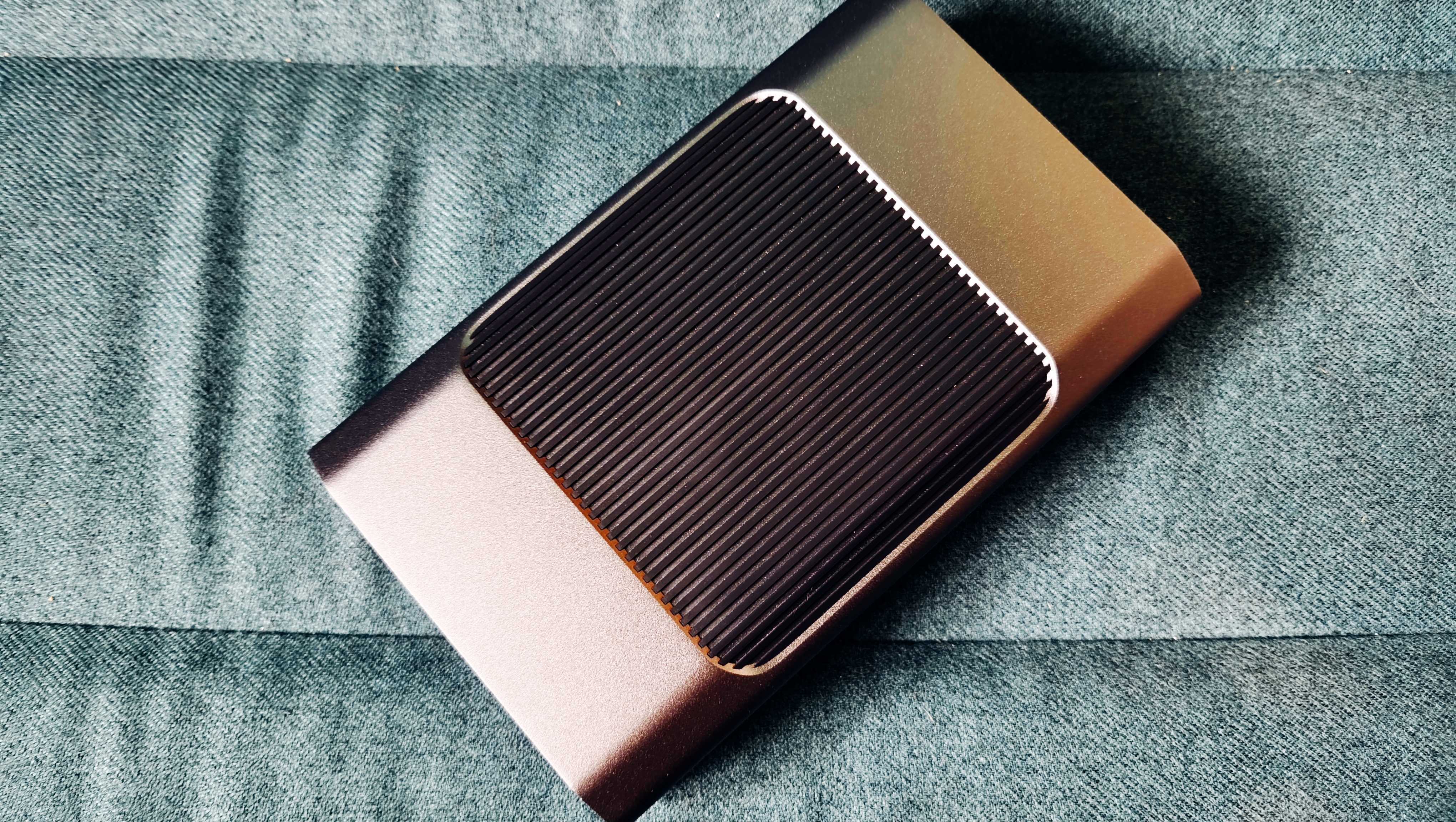 A grey and black SanDisk G-Drive sitting on a green sofa