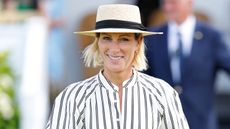 Zara Tindall, wearing a sunhat and striped dress, attends the Out-Sourcing Inc. Royal Windsor Cup Final polo match and a carriage driving display on June 22, 2025