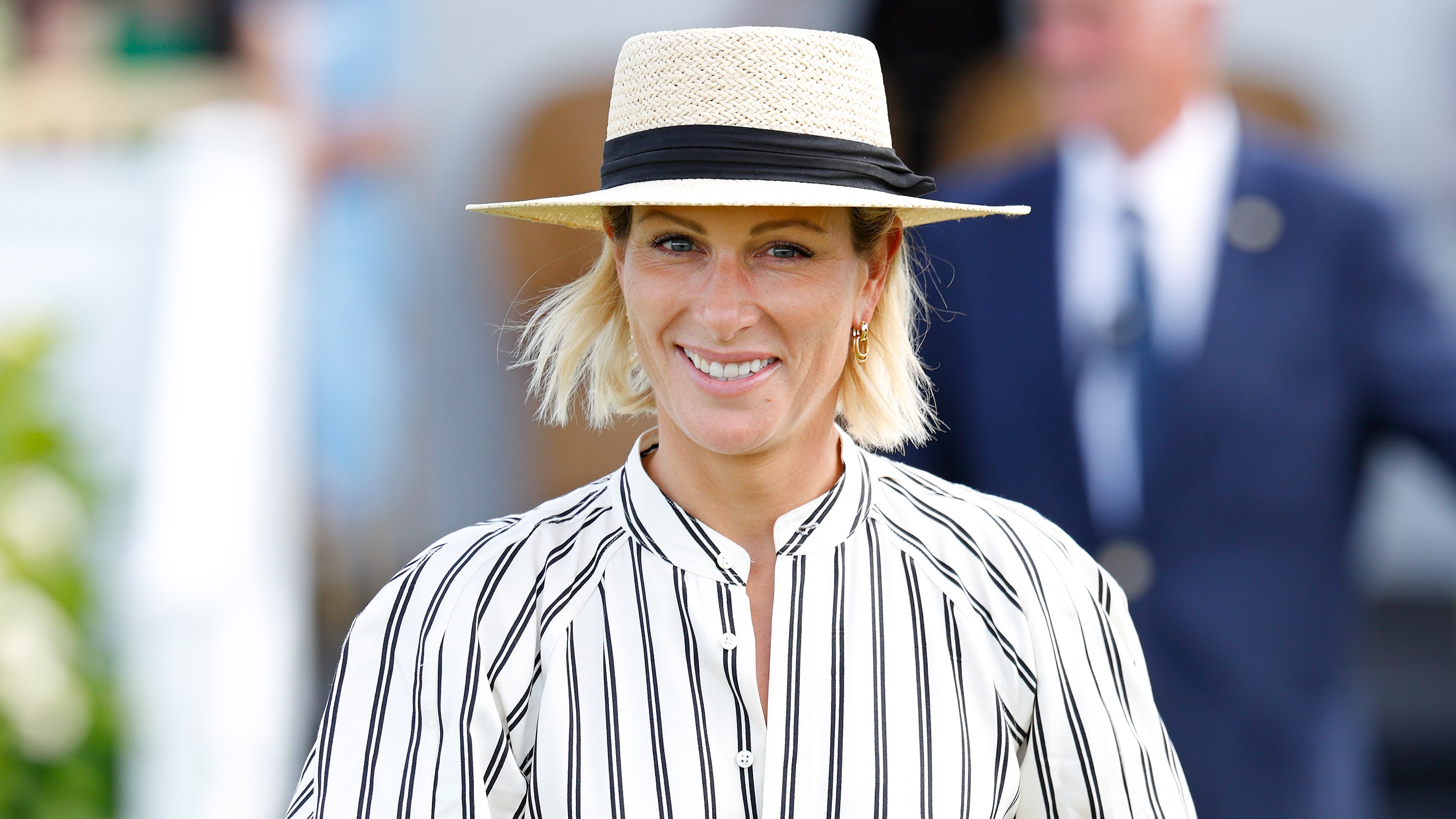 Zara Tindall, wearing a sunhat and striped dress, attends the Out-Sourcing Inc. Royal Windsor Cup Final polo match and a carriage driving display on June 22, 2025