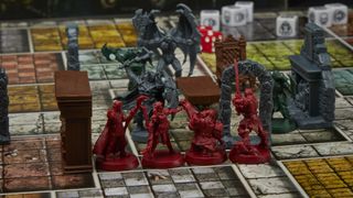 HeroQuest miniatures facing off with a knight and gargoyle