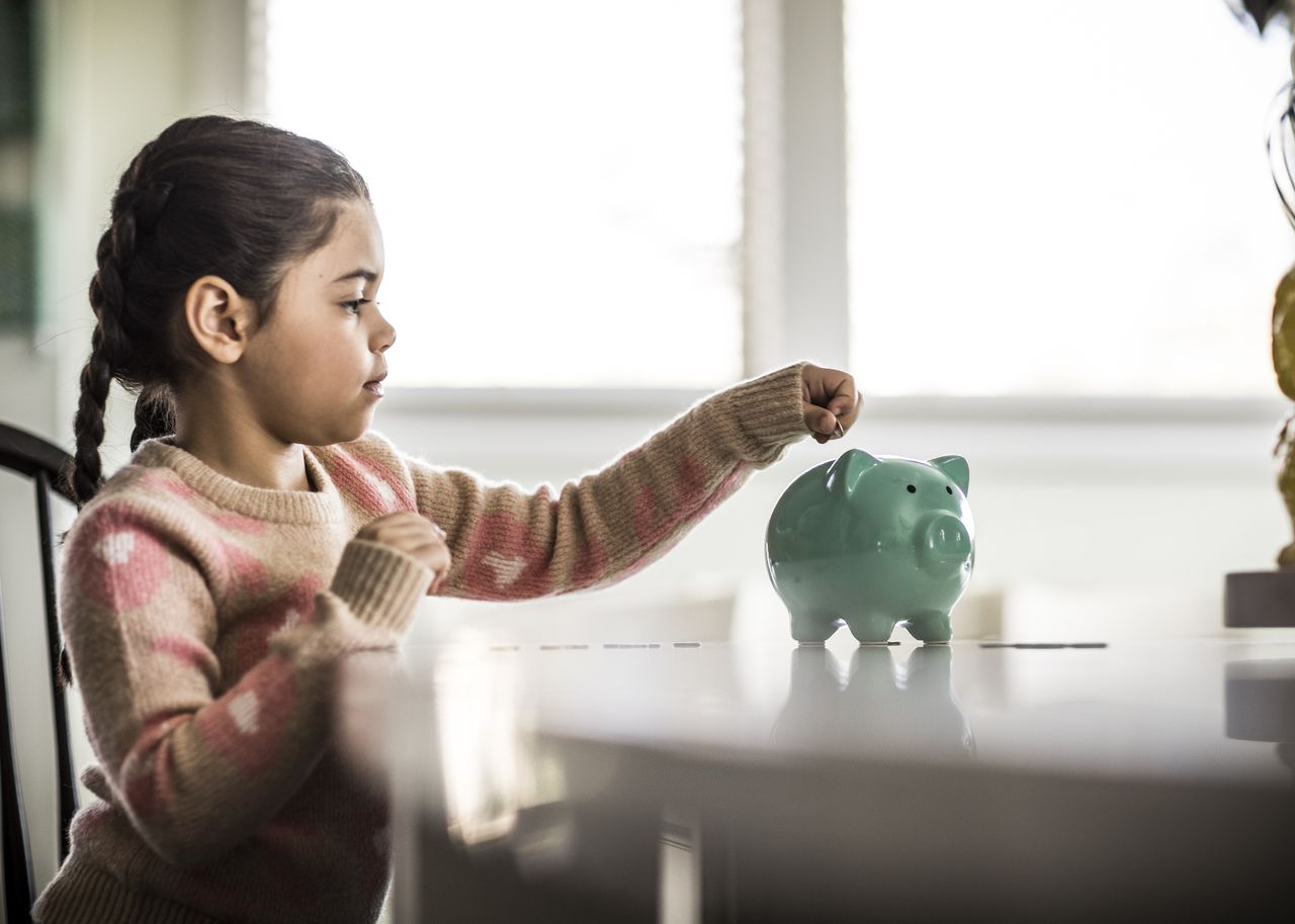 Girl putting money in piggybank