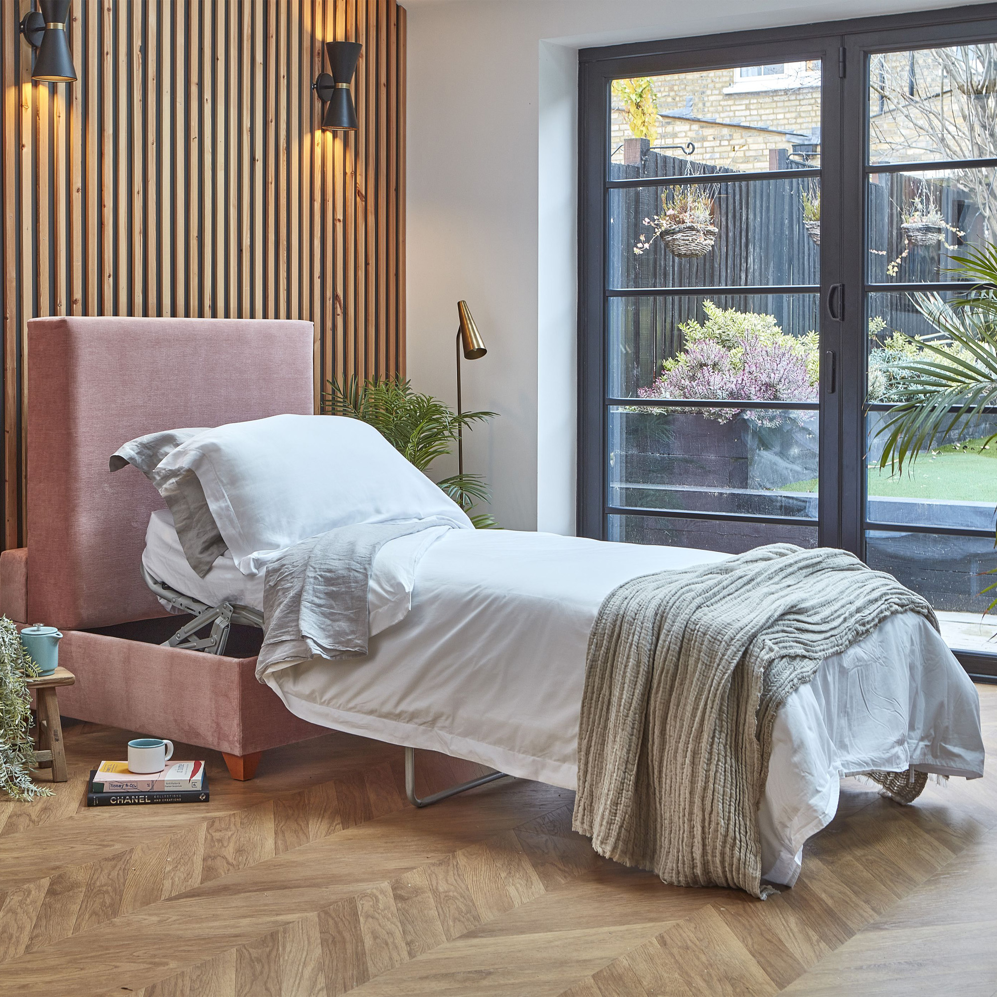 Darlings of Chelsea pink bed-in-a-box in a living room with a wooden parquet floor
