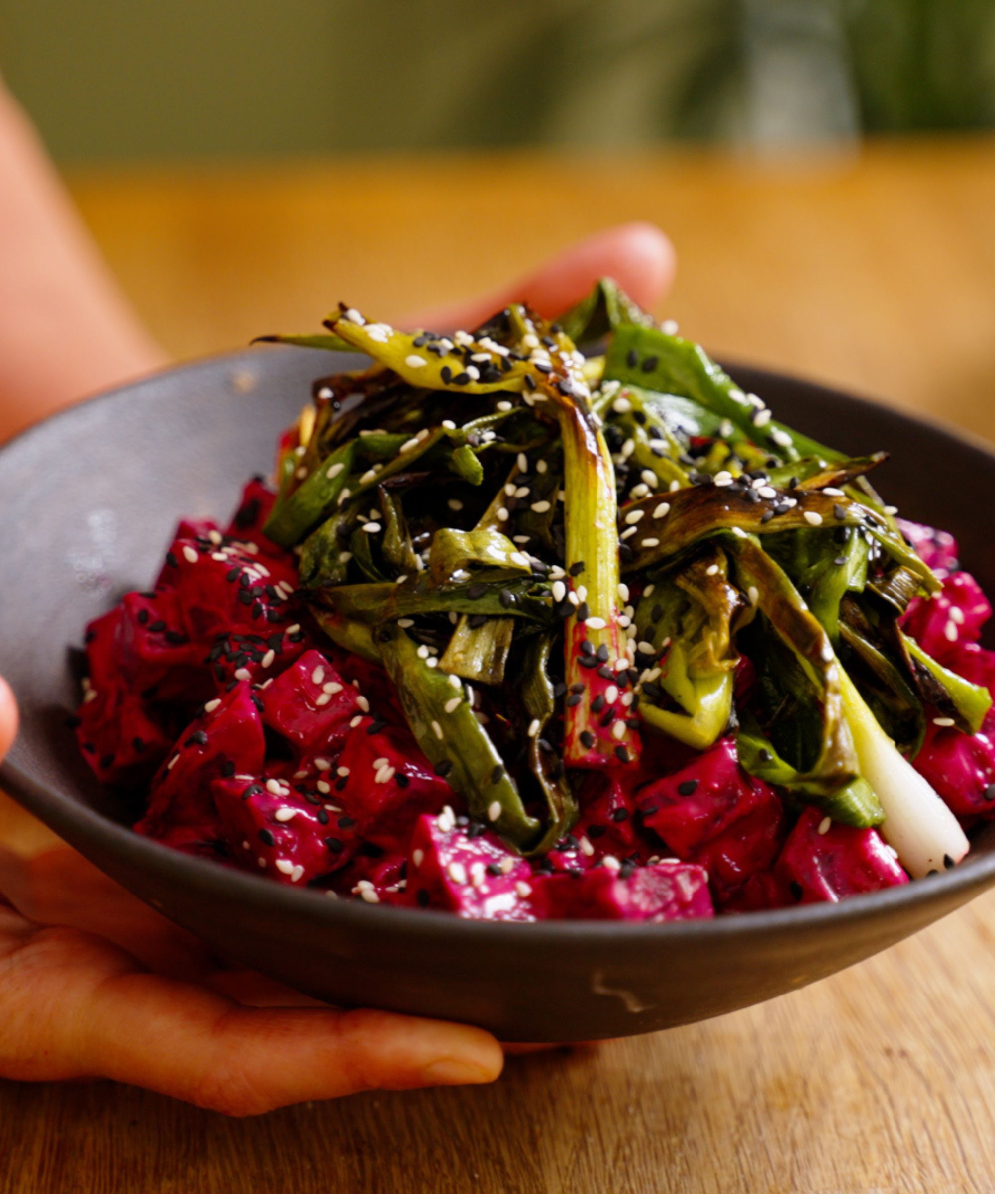 Bowl of chopped beetroot with charred scallions and sesame seeds