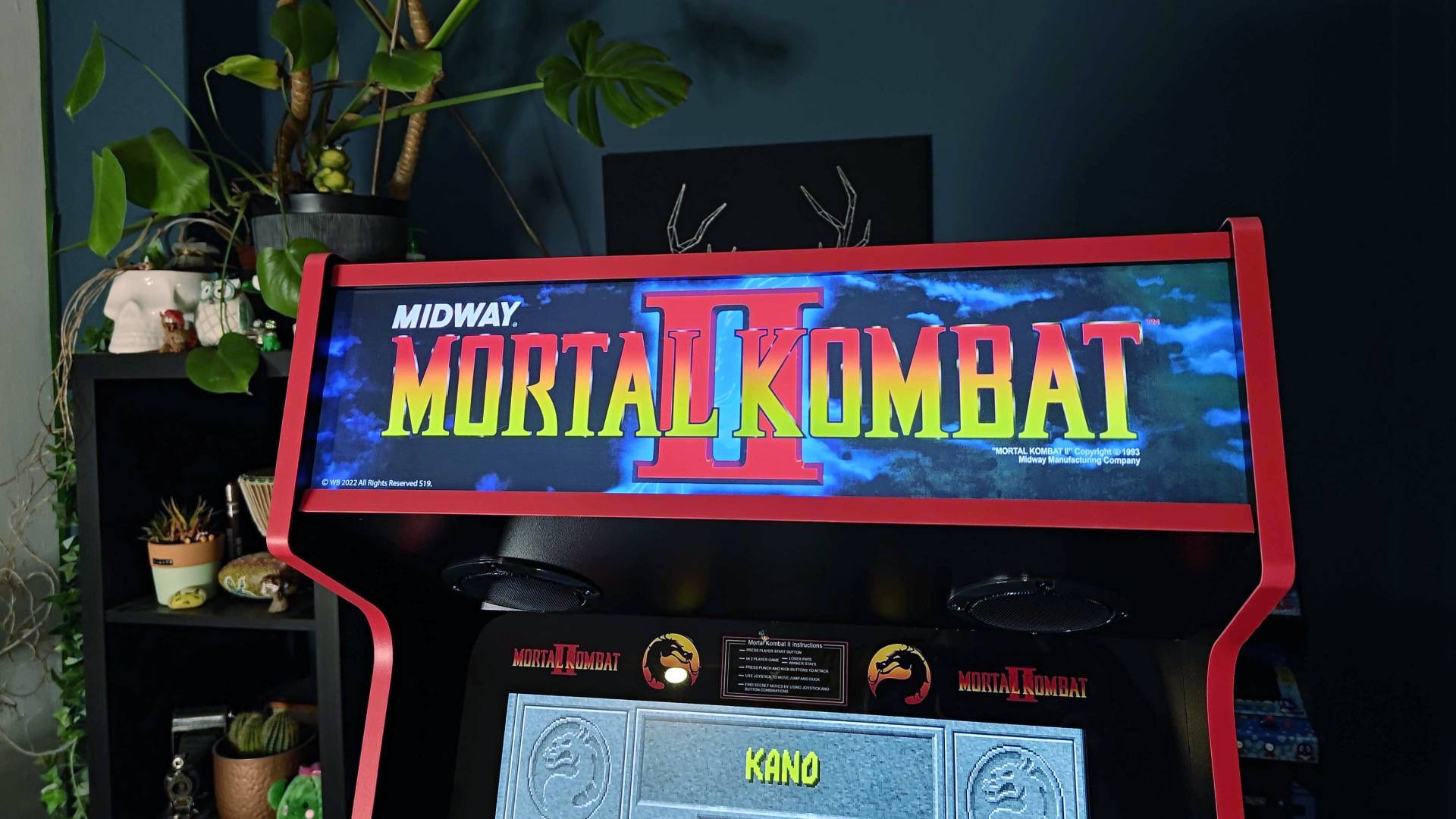 Close-up of Arcade1Up Mortal Kombat Deluxe machine illuminated marquee.