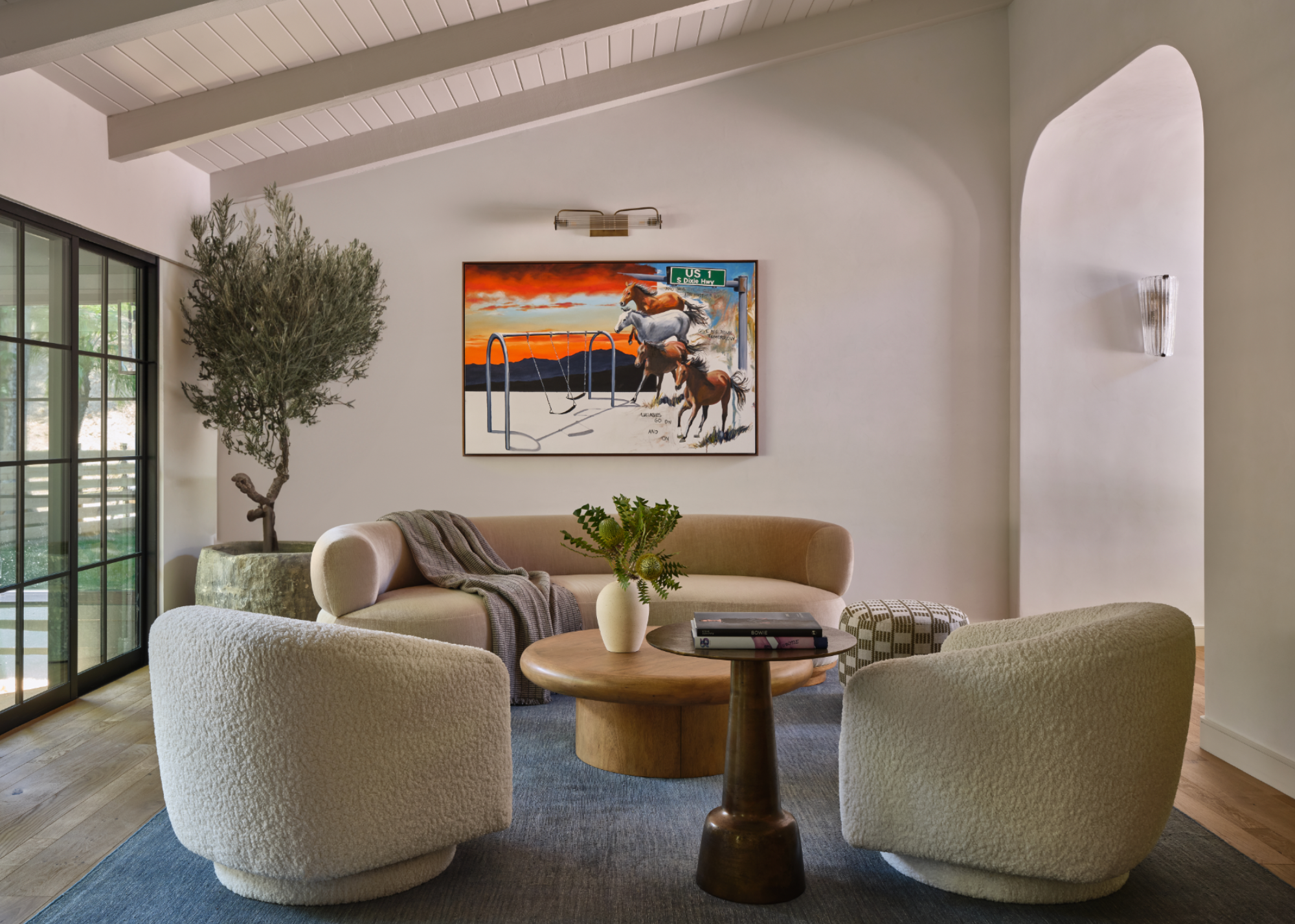 bright living area with curved, neutral furniture and house plants