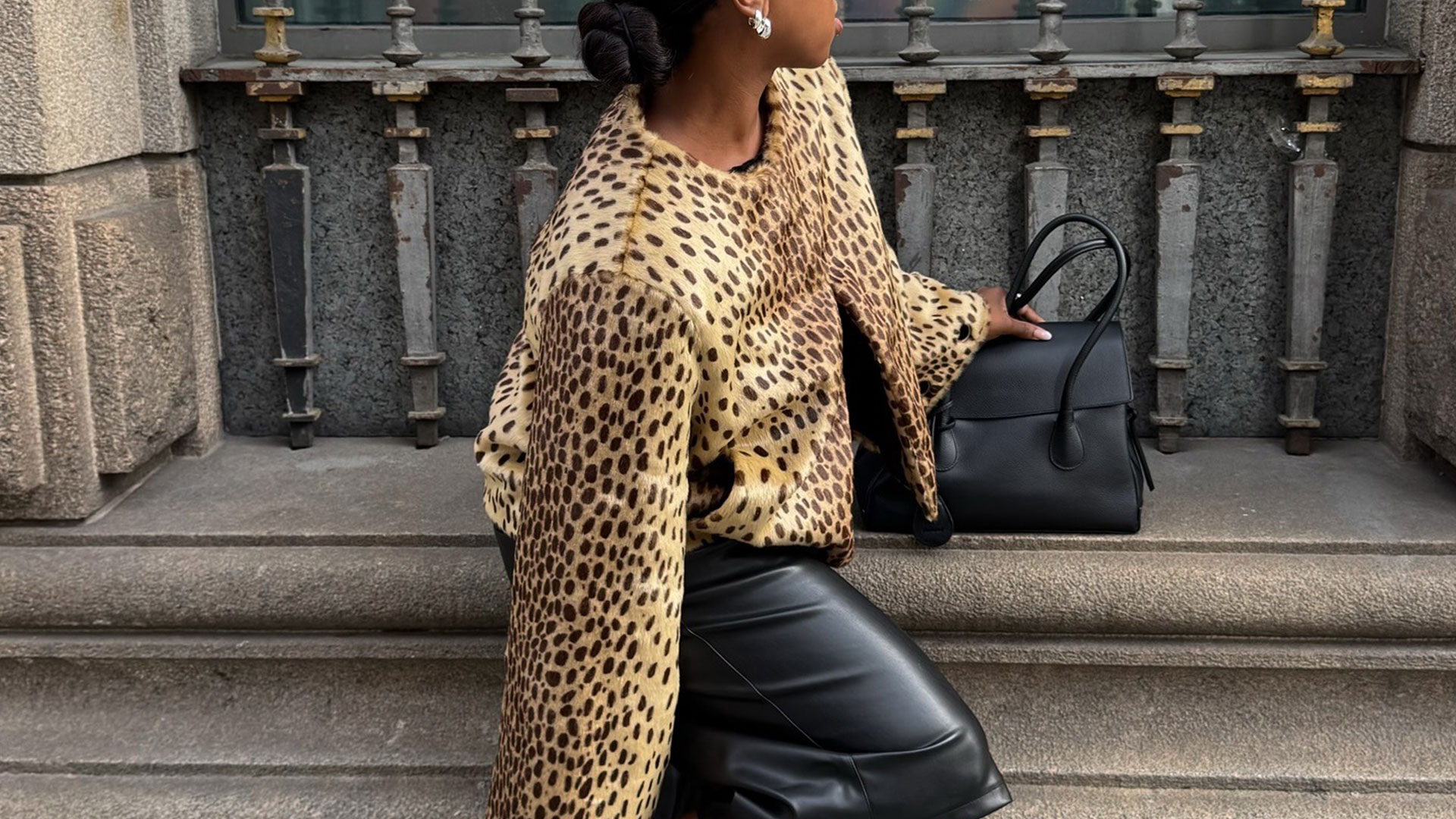 @nnennaechem wearing an animal print jacket, leather bermuda shorts, and black boots.