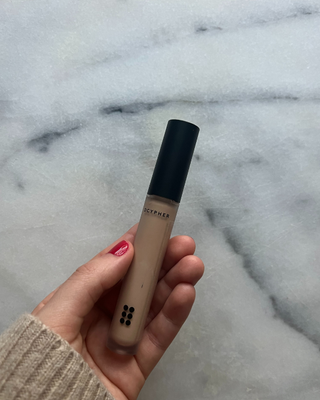 DCYPHER concealer review: Sofia holding the product