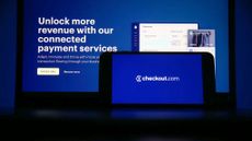 A Checkout.com logo on a laptop computer and mobile phone