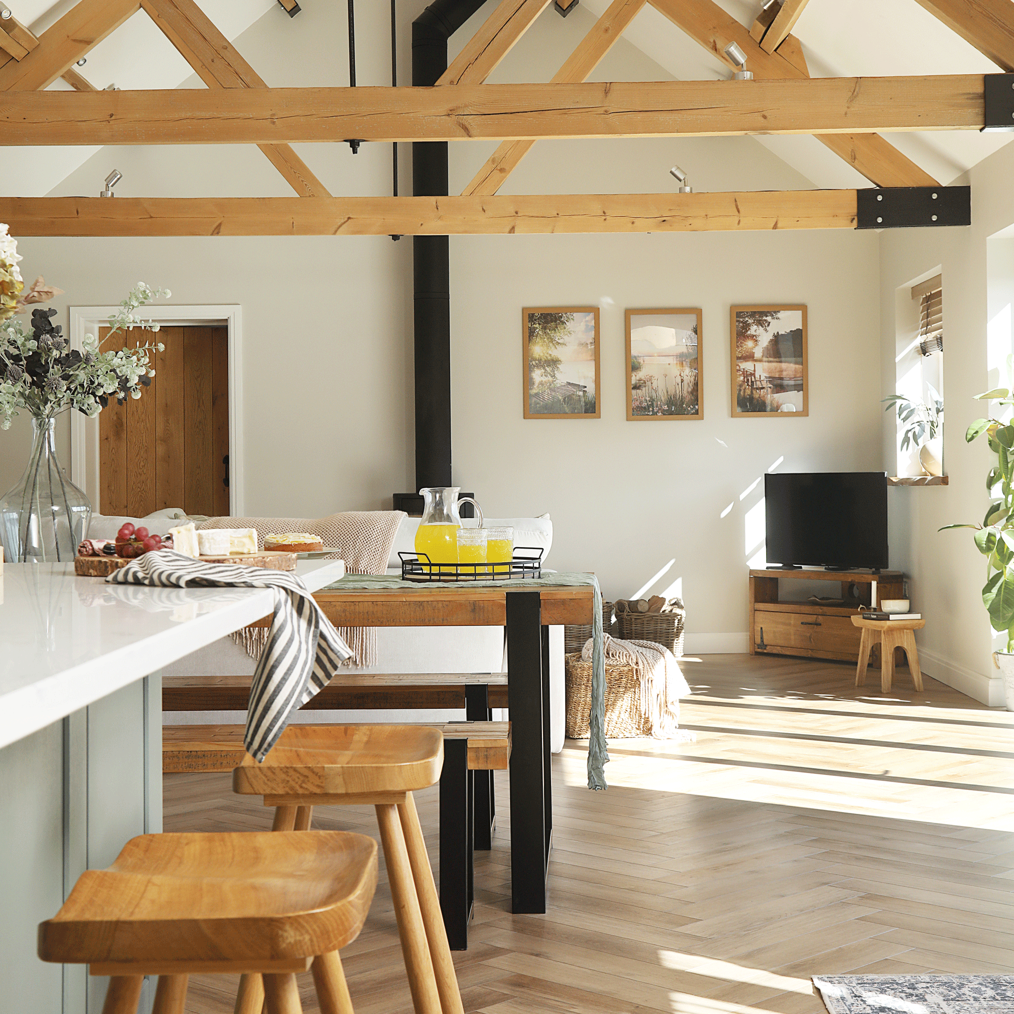 an open plan kitchen dining living space with vaulted ceilings and herringbone flooring
