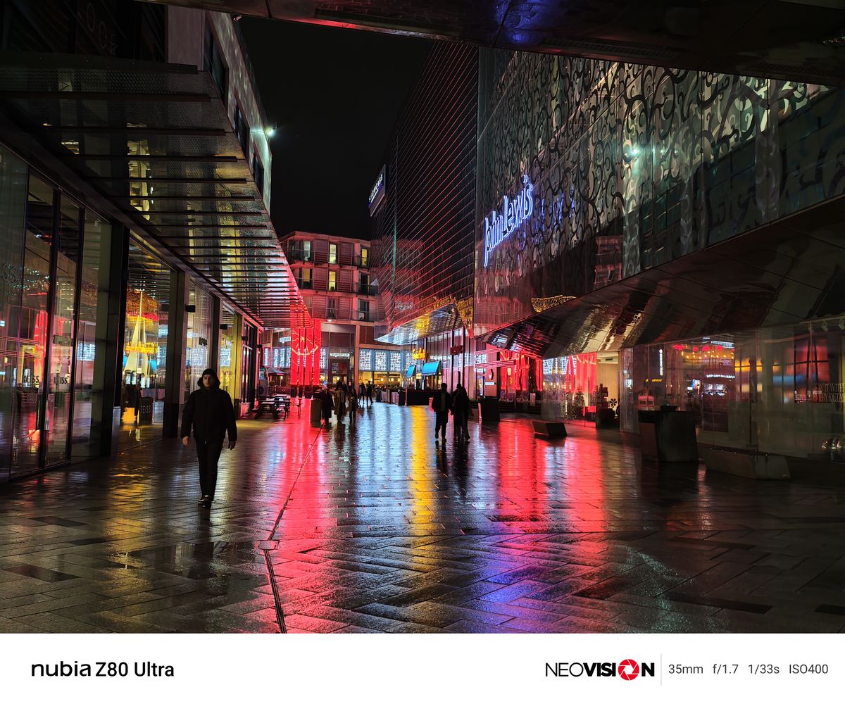 A shopping centre lit up at night with colorful lights