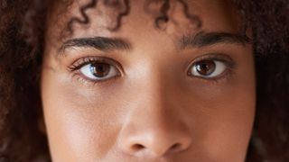 Close up of a young black woman's eyes as she looks at the camera