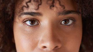 Close up of a young black woman&#039;s eyes as she looks at the camera