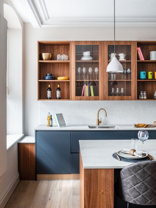 Wooden shelves, blue base cabinets and wooden kitchen island