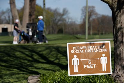 People are urged to social distance on a golf course.