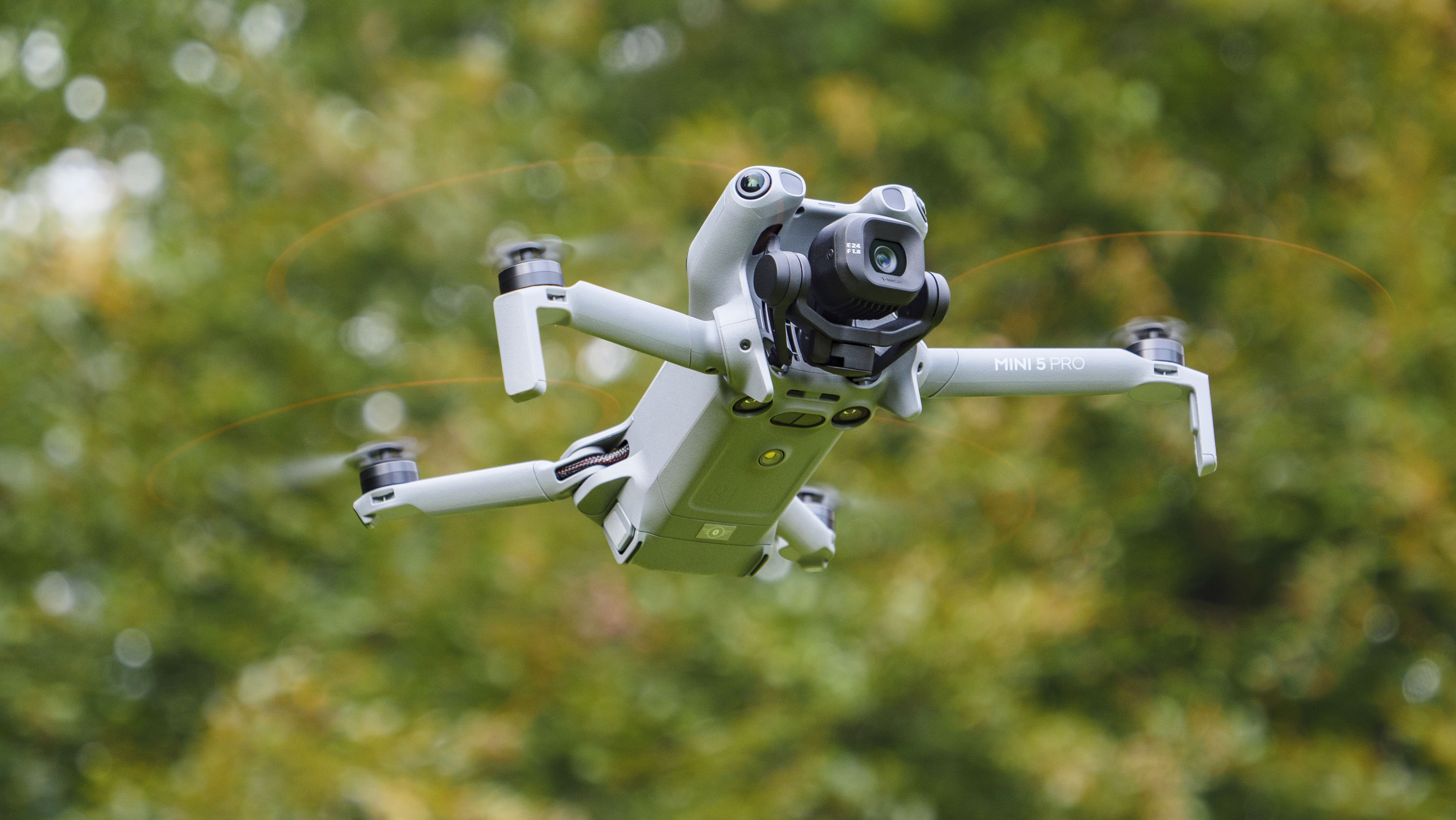 DJI Mini 5 Pro in flight with trees in the background