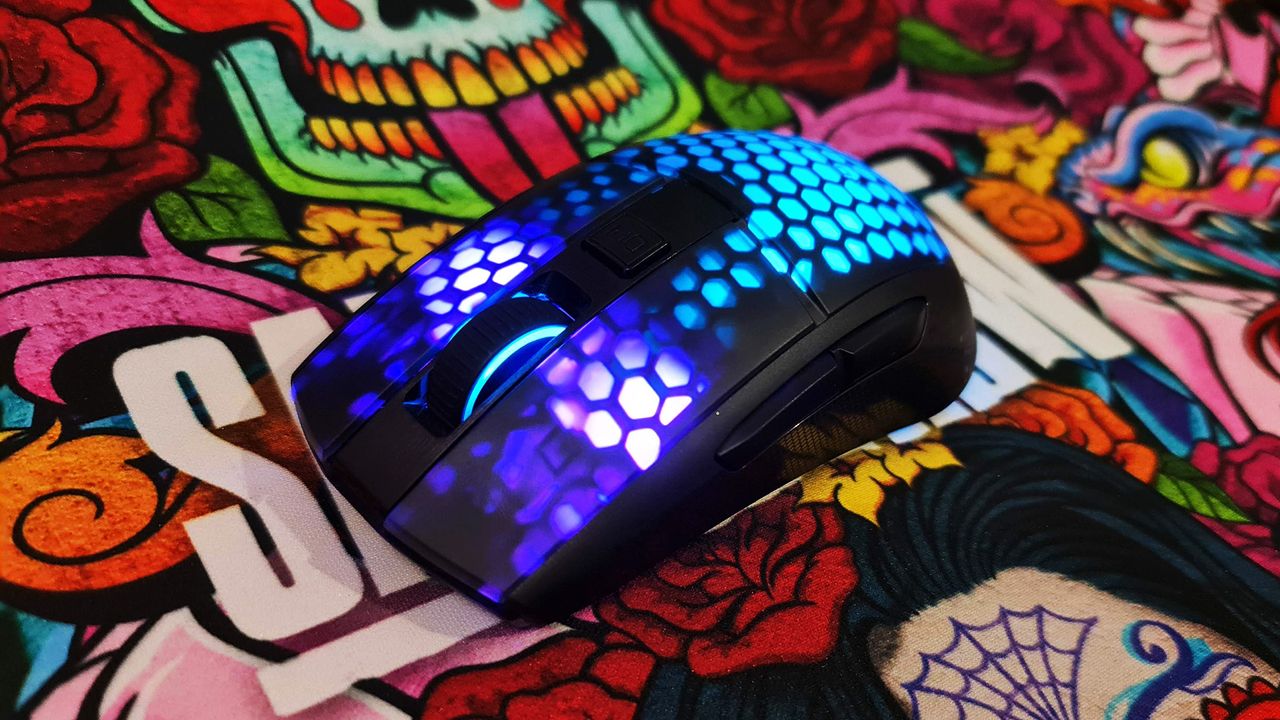 Roccat Burst Pro Air gaming mouse with RGB LEDs enabled on colourful deskmat.