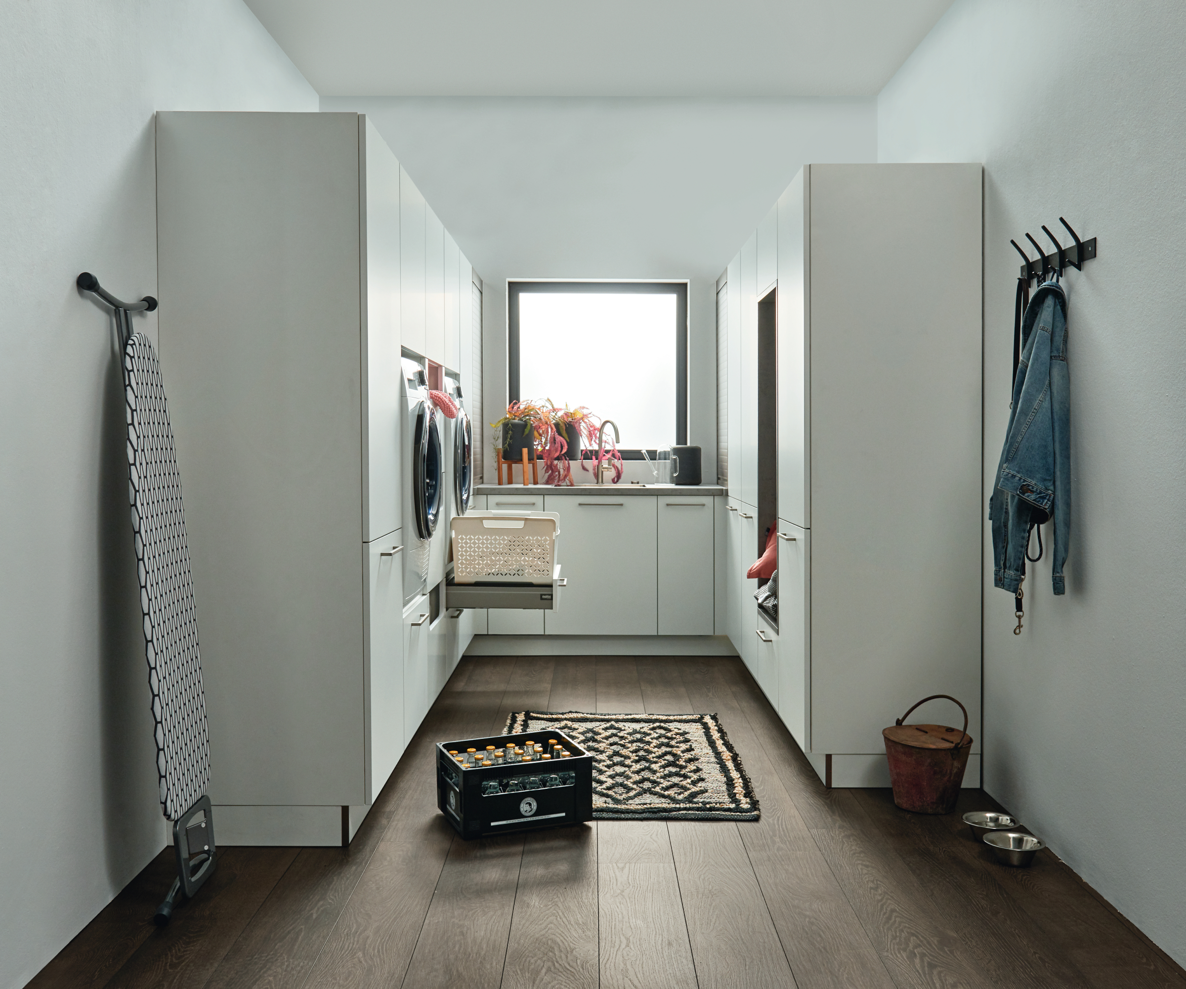 utility room with white cupboards and wooden floor