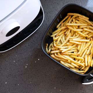 Air fryer on kitchen worktop cooking chips