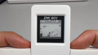 Close up of Ink-Boy Game Boy E-ink handheld docked on NES controller with Super Mario Land gameplay on screen.
