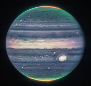 A composite image of Jupiter from red, yellow-green, and cyan filters, courtesy the James Webb Space Telescope. The Great Red Spot appears white because the huge storm's clouds reflect the sunlight. At the poles, the aurora appear in rainbow shades.