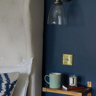 dark blue wall bedside shelf in bedroom