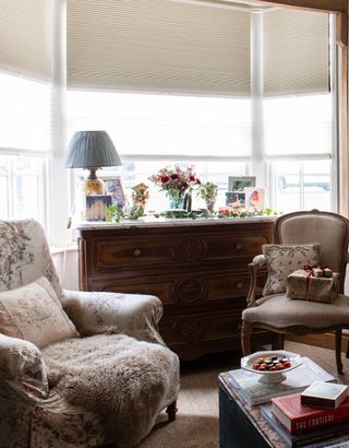 bay window with antique dark wood chest of drawers and armchairs