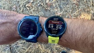 The Garmin Forerunner 965 and Coros Vertix 2S showing how much training load I earned across a 10K run.