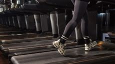 Woman's legs walking on treadmill in the gym