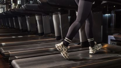 Woman's legs walking on treadmill in the gym