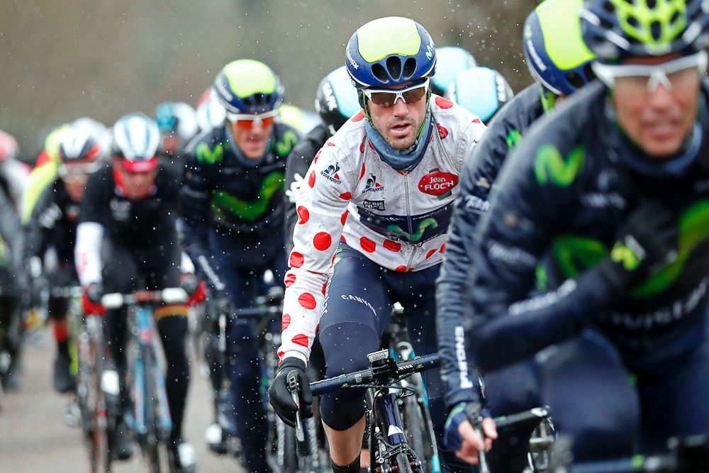 Jon Izaguirre (C) wearing the best climbers' polka dot jersey rides in the pack during the third stage