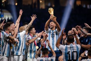 Sergio Aguero joins the Argentina players in their celebrations after winning the 2022 World Cup and lifts the trophy at the Lusail Stadium.