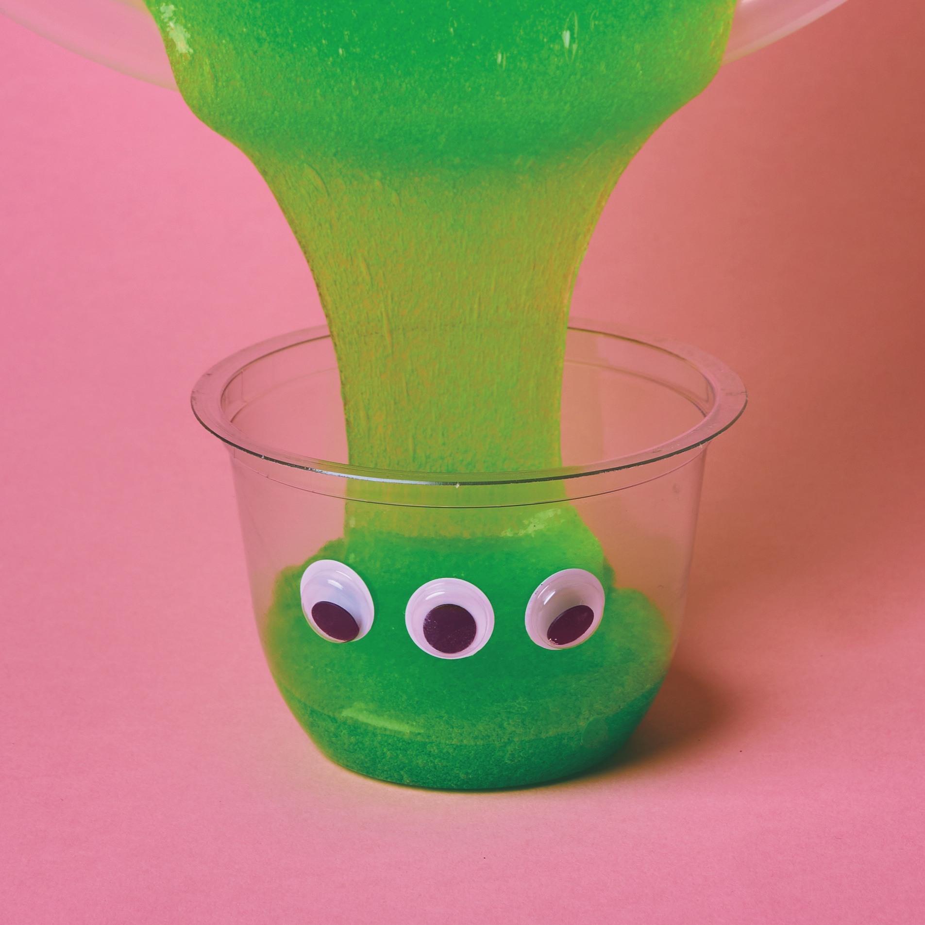 Slime falling into a plastic recipient with three goggly eyes