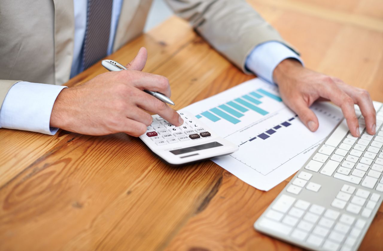 Cropped image of a businessman&amp;#039;s hands working on a calculator